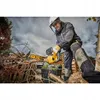 A person is using a yellow and black chainsaw to cut branches in an outdoor setting with a cloudy sky. Voir les images du produit