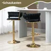 Two black velvet bar stools with gold bases are shown in a modern setting, possibly a kitchen or bar area. Produktbild-Vorschau