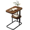 A small side table with a book, a cup of coffee, and a small alarm clock on it. Produktbild-Vorschau