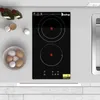 A modern kitchen countertop with a black induction cooktop, eggs in a bowl, and bottles of olive oil. Náhľad obrázku produktu