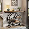 A console table with a circular shelf unit is placed in a hallway next to a door and a sofa. Podgląd zdjęcia produktu