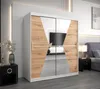 A bedroom scene featuring a modern wardrobe with sliding doors, a bedside table, and a bed in the background. Produktbild-Vorschau