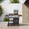 A gas grill with a pizza oven and griddle attachment, set up on a wooden deck outdoors. Produktbild-Vorschau