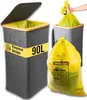 A trash can with a lid and a yellow trash bag being held by a hand. Náhľad obrázku produktu