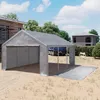 A gray tent hall or carport is set up in a yard with a house under construction in the background and a truck partially visible inside the tent. Voir les images du produit