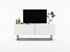 A modern white TV stand with a black metal frame, featuring a large black TV and decorative items on top, including vases and plants. Produktbild-Vorschau