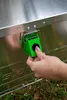 A hand is shown closing a green latch on a silver aluminum box. Produktbild-Vorschau