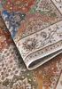 A close-up view of a folded rug with a detailed floral pattern. Voir les images du produit