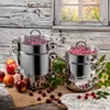 Two stainless steel steamers filled with cherries and raspberries, placed on a wooden surface with some fruits and leaves around them, with a window in the background. Produktbild-Vorschau