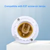 A close-up of a white E27 lamp socket adapter with a gold-colored socket, placed on a white surface with a light blue background. Podgląd zdjęcia produktu