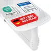 A close-up product shot of a white mattress wedge or gap filler, featuring several quality and branding labels. Podgląd zdjęcia produktu