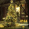 A decorated Christmas tree in the snow at night, with rain falling. Náhled obrázku produktu