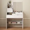 A white vanity table with a mirror and drawers, displaying various makeup and skincare products. Produktbild-Vorschau