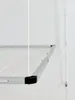 A close-up view of a ceiling-mounted retractable clothes drying rack against a white wall. Voir les images du produit