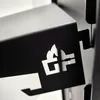 A close-up shot of a black metal grill component with a cutout logo. Produktbild-Vorschau