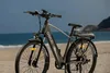An e-bike is parked on a sandy beach with the ocean and a rocky coastline in the background. Anteprima dell’immagine prodotto