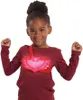 A young girl wearing a red shirt and a glowing amulet. Náhľad obrázku produktu