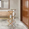 A wooden drying rack with a white towel is placed on a marble-tiled floor in a modern bathroom. Podgląd zdjęcia produktu