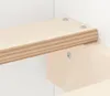 A close-up view of a wooden shelf attached to a white wall with screws. Voir les images du produit