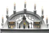 A white LED wooden silhouette of a village scene with houses and a church, illuminated by warm white lights. Produktbild-Vorschau