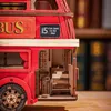 A close-up view of a wooden model of a London double-decker bus, showing intricate details of the interior stairs and signage. Anteprima dell’immagine prodotto