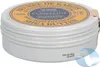 A close-up, slightly angled view of a L'Occitane Shea Butter tin. Voir les images du produit