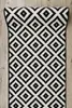 A black and white diamond patterned rug laid on a wooden floor. Anteprima dell’immagine prodotto