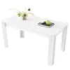 A white rectangular dining table with decorative fluted legs, set against a white background. A small potted plant and a book with two green apples are placed on the tabletop. Produktbild-Vorschau