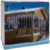 A wooden cabin with icicle lights draped over the porch during winter. Voir les images du produit