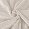 A close-up of beige velour fabric, folded and swirled. Anteprima dell’immagine prodotto
