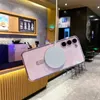 A pink phone case with a magnetic charger attached is shown in a cafe setting. Anteprima dell’immagine prodotto