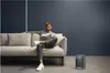 A man is sitting on a couch reading a book next to a space heater. Anteprima dell’immagine prodotto