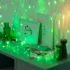 A desk with decorative items and green LED string lights. Produktbild-Vorschau