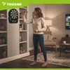 A woman is playing darts in a living room setting. Podgląd zdjęcia produktu