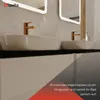 A modern bathroom vanity with two white ceramic sinks and rose gold faucets, reflected in illuminated mirrors. Produktbild-Vorschau