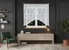 A living room scene featuring a window with white lace curtains, a wooden cabinet, a green armchair, and a potted plant. Náhled obrázku produktu