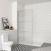 A modern bathroom with a toilet, a walk-in shower, and tiled walls and floor. Produktbild-Vorschau