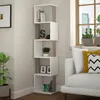 A modern white and light mocha corner bookshelf filled with books and decorative items, placed next to a window and a sofa. Voir les images du produit