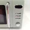A close-up view of the side of a retro-style green microwave oven. Náhľad obrázku produktu