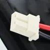 Close-up of a white electrical connector with red and black wires attached. Podgląd zdjęcia produktu