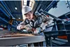 A man is using an angle grinder in a workshop. Voir les images du produit