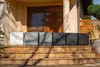Several planters of varying shades of gray and white are lined up on a set of outdoor stairs in front of a house. Anteprima dell’immagine prodotto