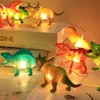 A collection of dinosaur-shaped string lights, illuminated from within, arranged on a surface. Produktbild-Vorschau