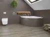 A bathroom with a bathtub and toilet, featuring tiled walls and wooden floors. Voir les images du produit