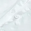 A close-up view of white fabric with a button and stitching. Produktbild-Vorschau