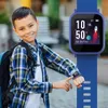 A young boy wearing a backpack and a plaid shirt is showing off his blue smartwatch. Anteprima dell’immagine prodotto