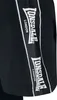 A close-up of a black t-shirt with a white Lonsdale London logo tape on the side. Produktbild-Vorschau