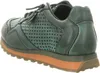 A side view of a green sneaker with an orange sole. Voir les images du produit