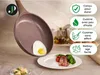 A frying pan with an egg and bacon on a plate, with text overlays describing product features. Voir les images du produit