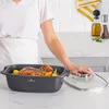 A person is placing the lid on a roasting pan filled with cooked food. Podgląd zdjęcia produktu